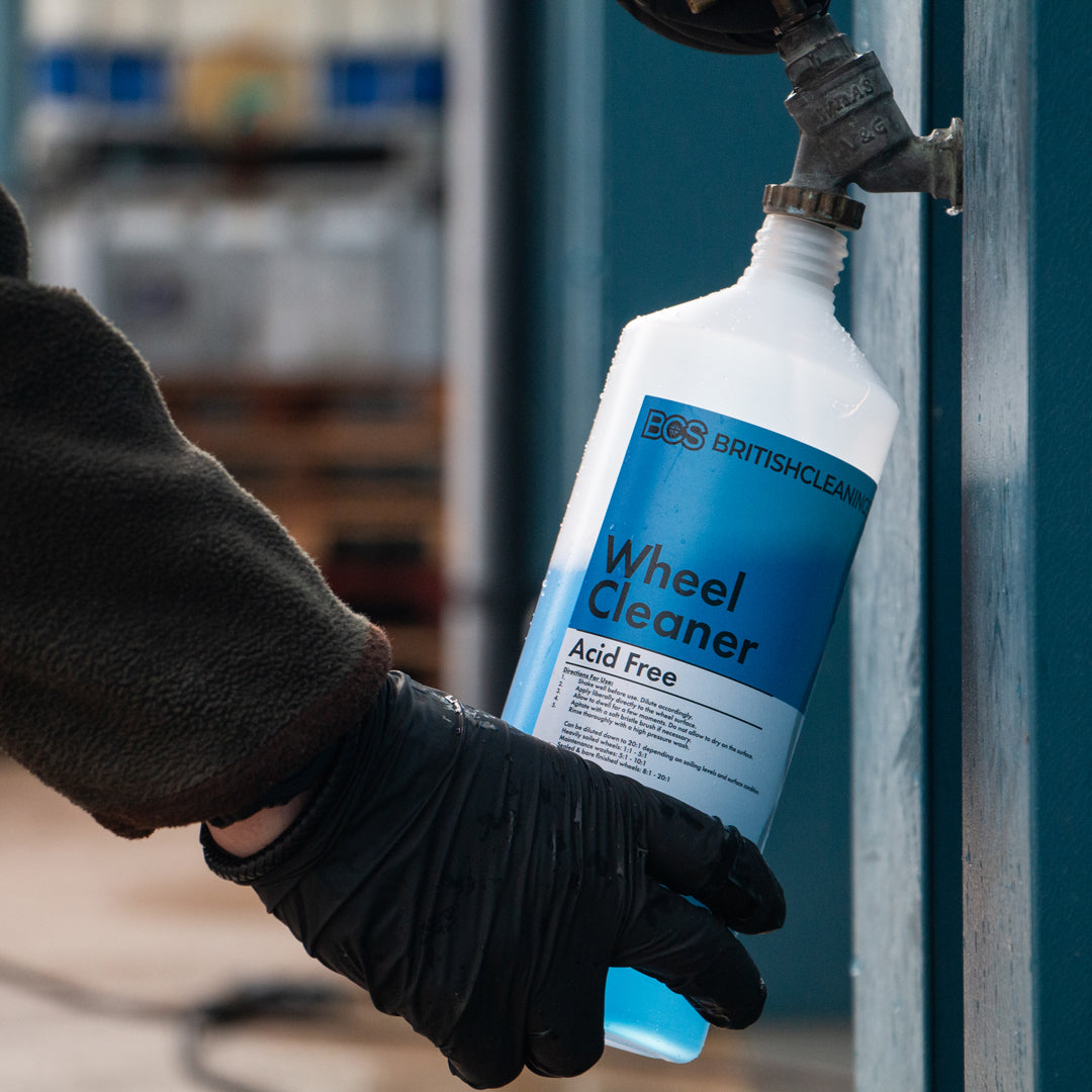 Person holding a bottle of BCS Acid Free Wheel Cleaner for dilution.