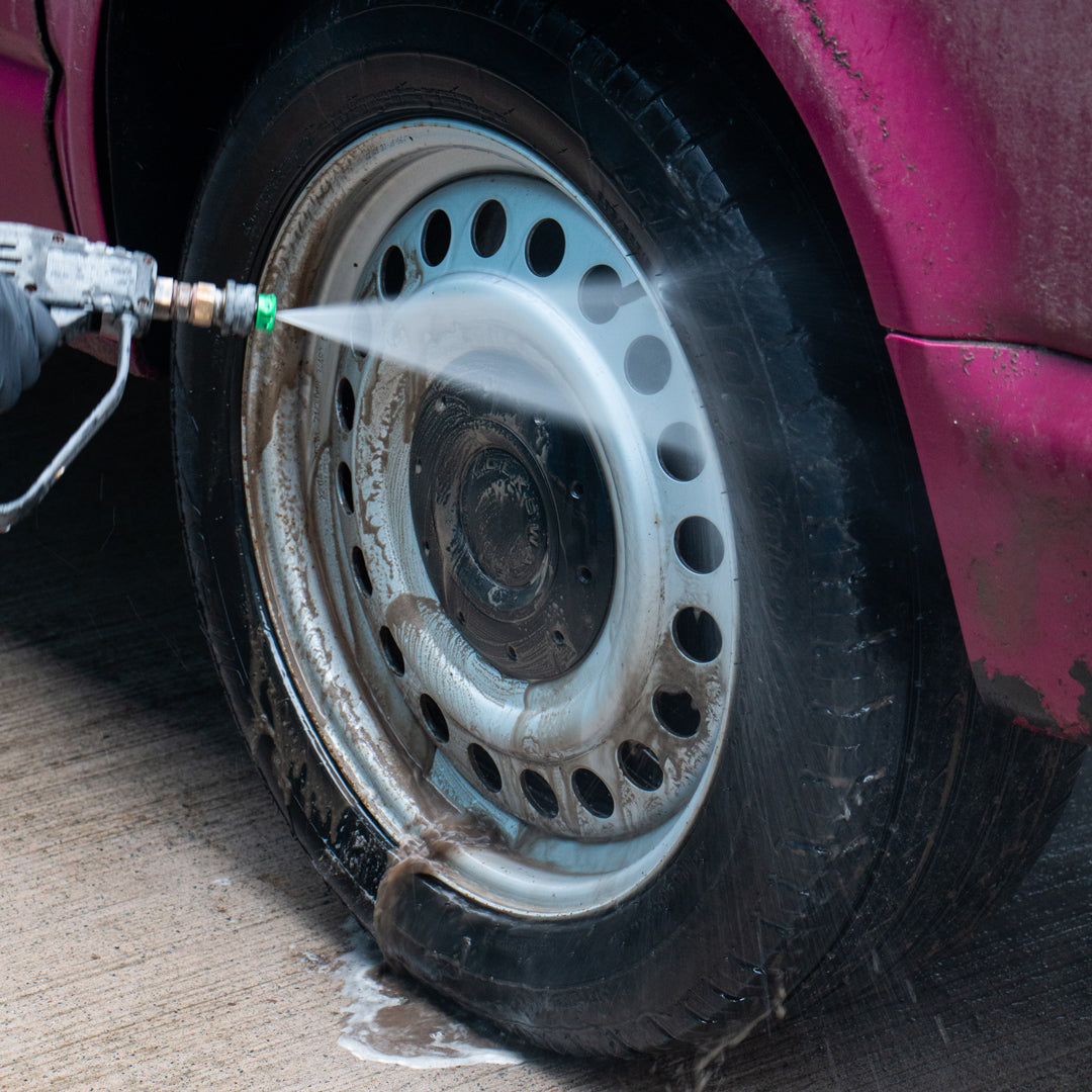 Car wheel being rinsed after being cleaning with an acid free wheel cleaner