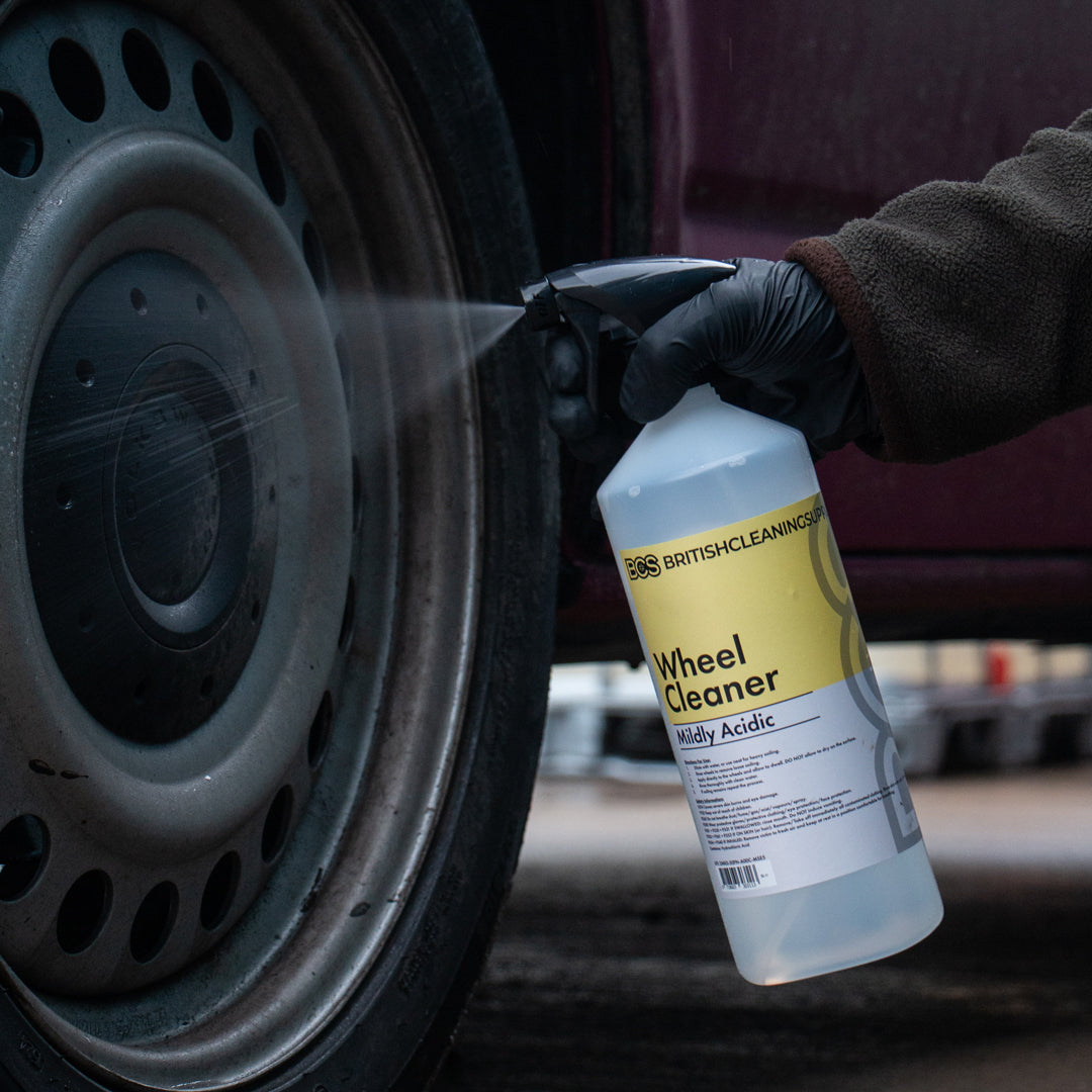 Person spraying a car wheel with a bottle of British Cleaning Supplies Wheel Cleaner.