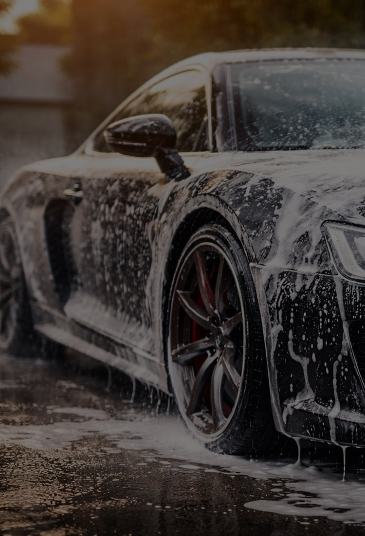 Black sports car being washing with soap
